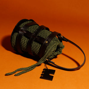 Handcrafted leather and crochet bucket bag inspired by castle doors, featuring black and brown leather with khaki green and light brown crochet bucket. Designed and made in Greece."
