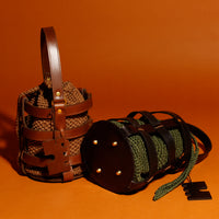 Handcrafted leather and crochet bucket bag inspired by castle doors, featuring black and brown leather with khaki green and light brown crochet bucket. Designed and made in Greece."